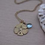 Gold Sand Dollar necklace with topaz gemstone